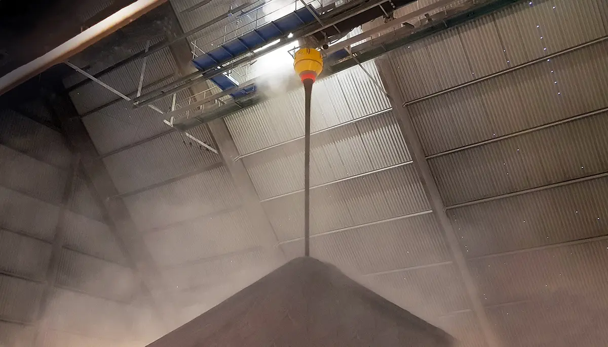 Dust Reduction Hopper in gebruik bij opslagloods van haven in Zweden, vermindert stofvorming tijdens bulkoverslag.