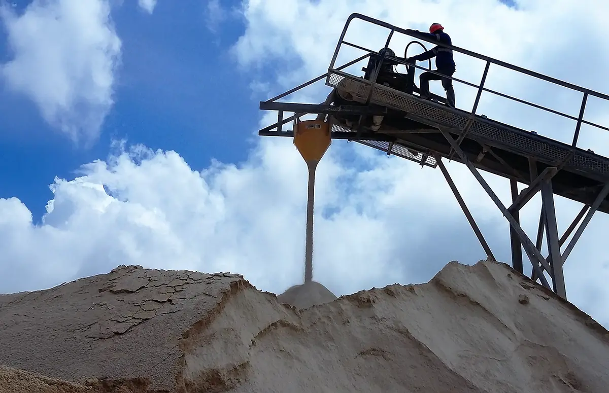 Toepassing van de Dust Reduction Hopper bij bulkverwerking (bijvoorbeeld zand), waarbij een medewerker veilig bij de verlading kan werken.