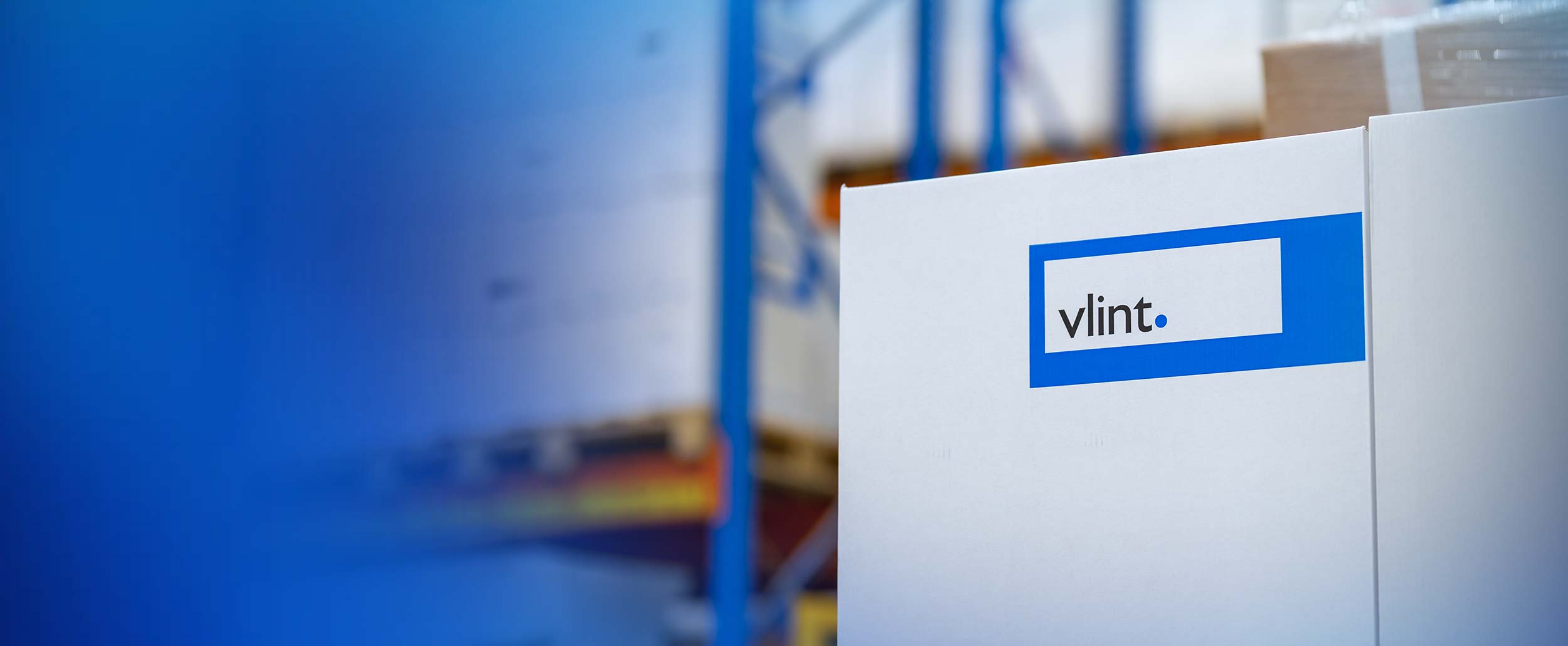 vlint verzenddoos met blauw vlint logo met groot magazijn op de achtergond